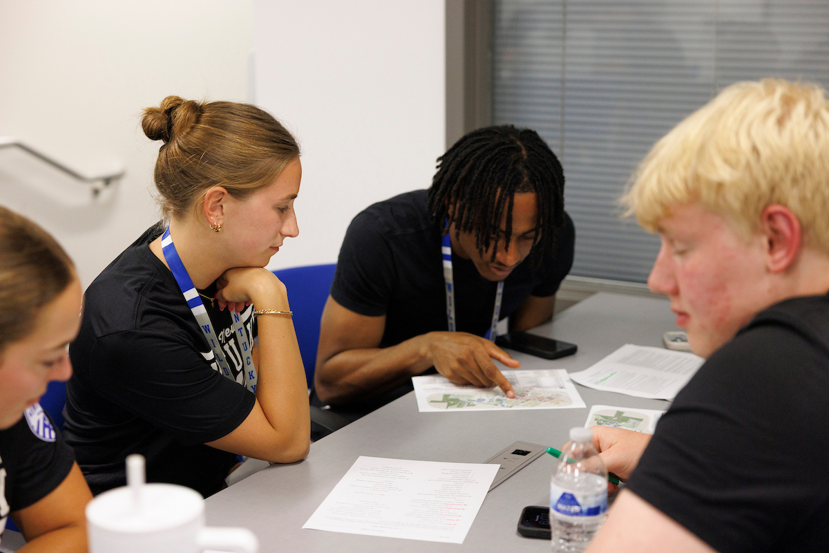 A picture of student-athletes looking over paperwork