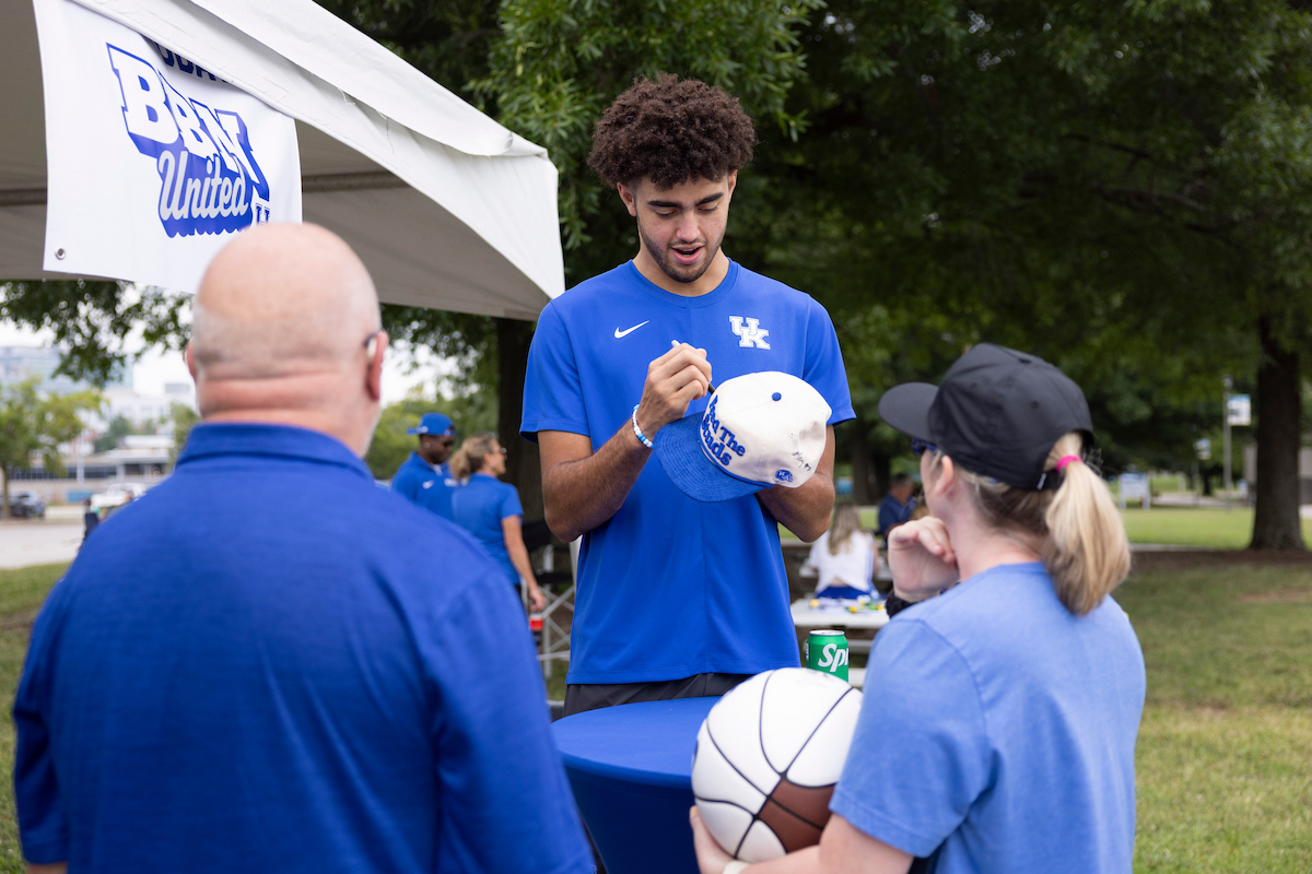 A picture of Malachi Moreno autographing a basketball