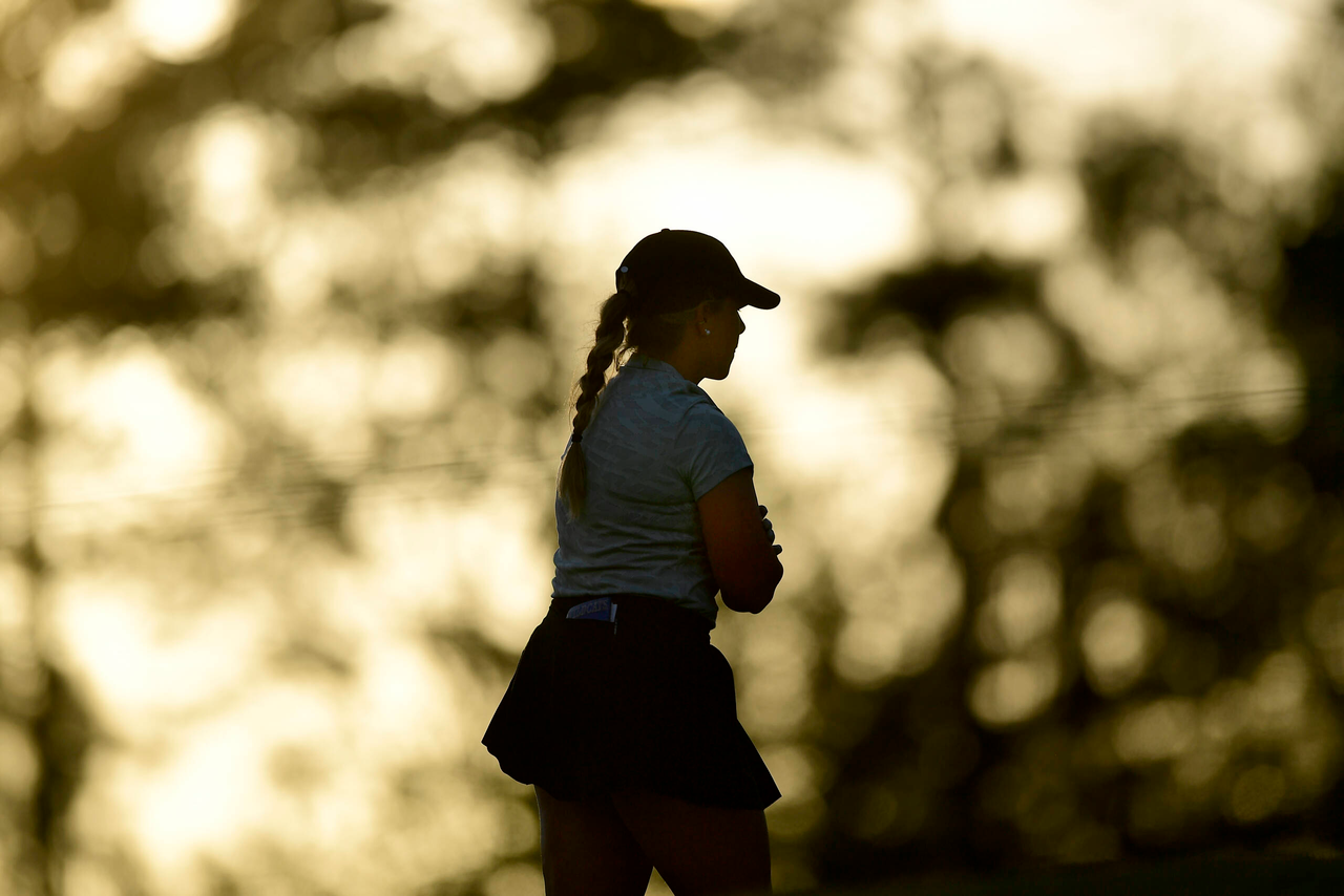 Jensen Castle of the United States is silhouetted by the setting sun on No. 14 during the second round of the Augusta National Women's Amateur at Champions Retreat Golf Club, Thursday, March 31, 2022.