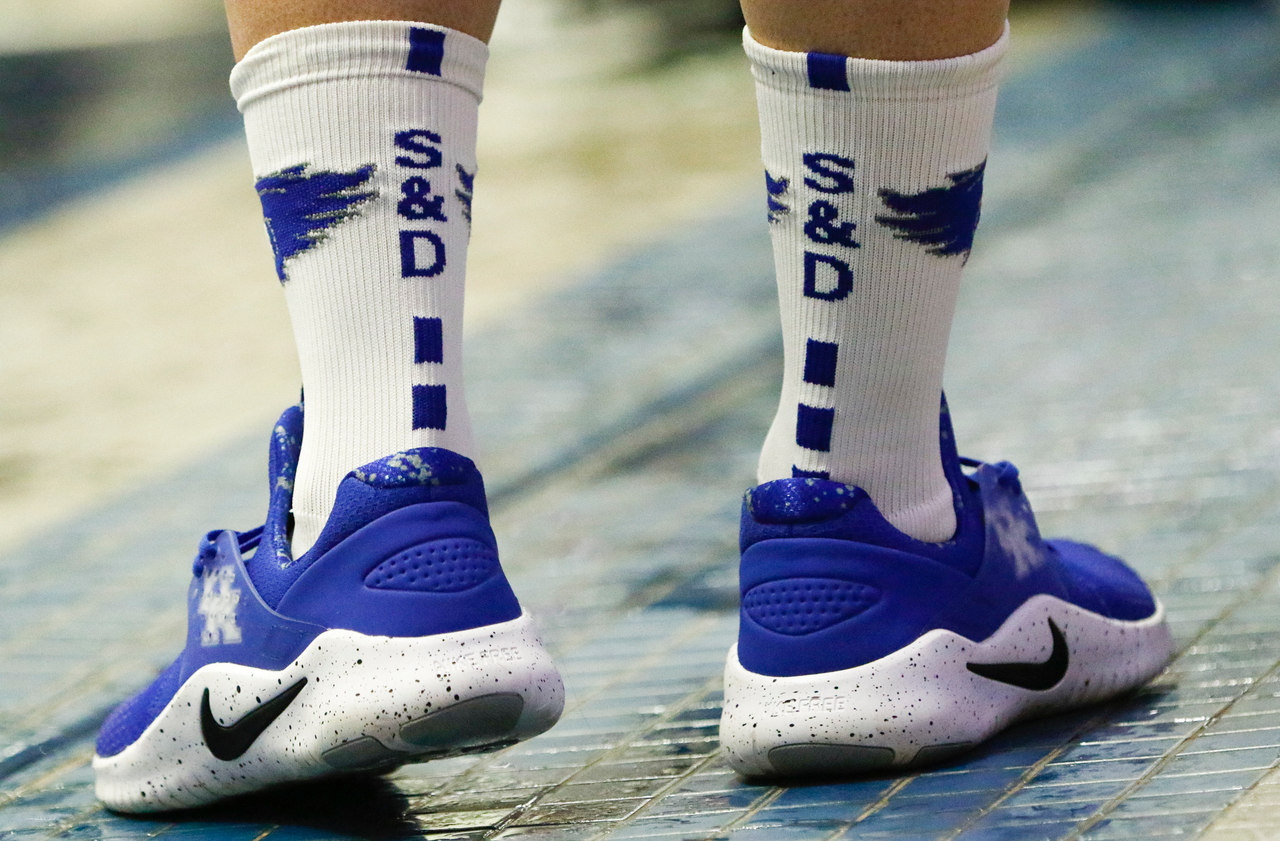 A Kentucky swimmer dons Kentucky Swim & Dive socks by the pool during the final day of the 2019 SEC Swimming and Diving Championships in the Gabrielsen Natatorium at the University of Georgia in Athens, Ga., on Saturday, Feb. 23, 2019. (Casey Sykes)